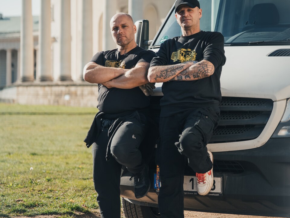 Dva členové týmu u stěhovacího vozu